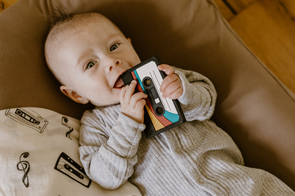Baby enjoying the Cassette Mix Tape Teether, combining retro 80s and 90s vibes for teething relief.