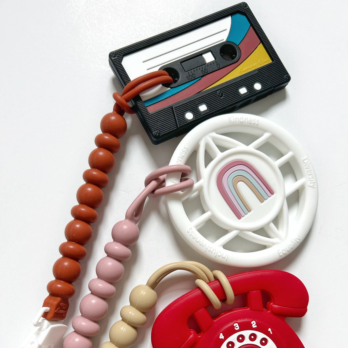 Cassette Mix Tape Teether alongside colorful teething toys reflecting retro 80s and 90s vibes for teething relief.