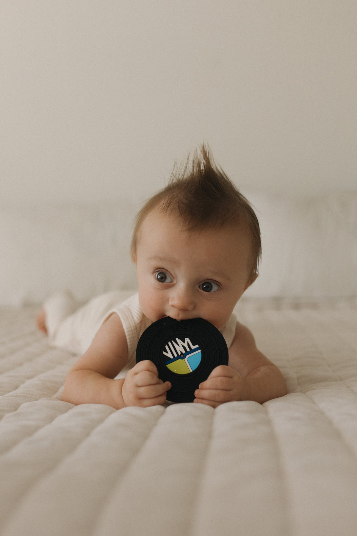 Vinyl record silicone baby teether held by a baby, perfect for stylish teething solutions.