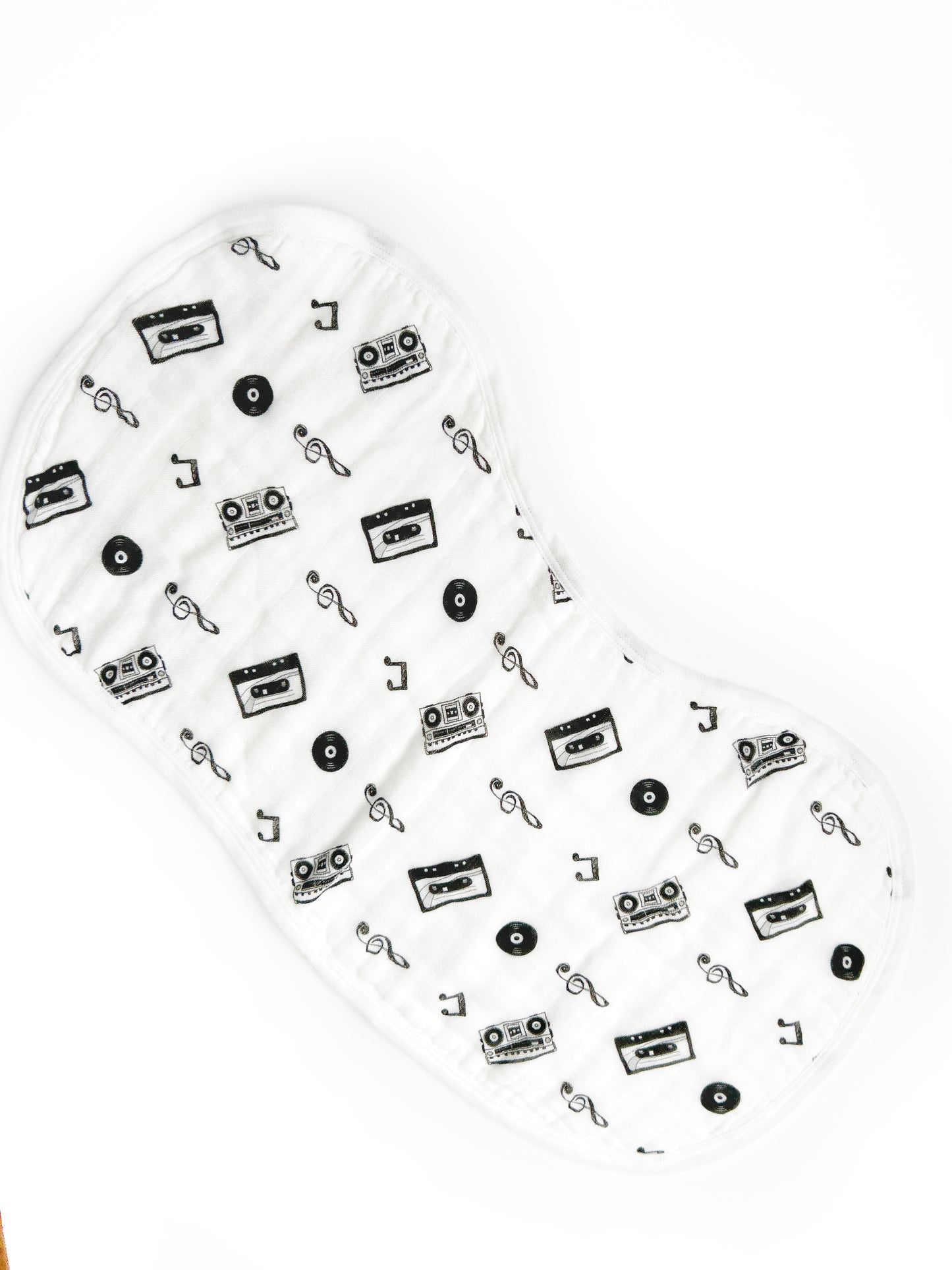 one white ergonomic burp rag showing details in black of vinyl record, boom box and cassette teether with music notes on them.