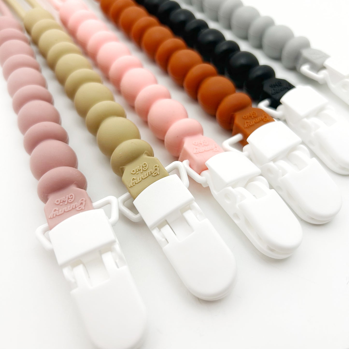 Colorful silicone teether clips on a white background
