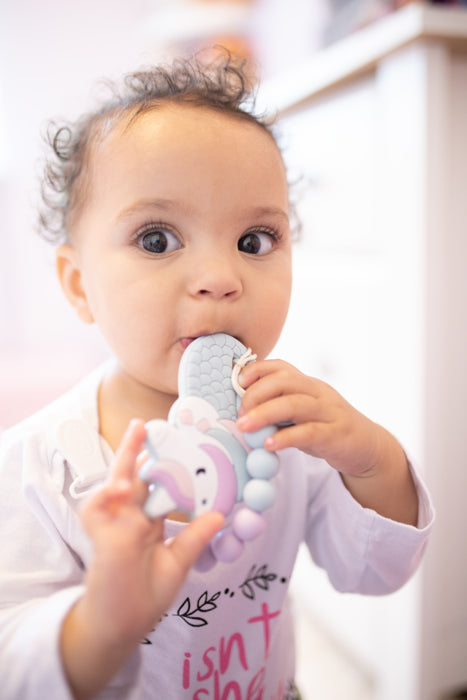 girl with chewing teething toy