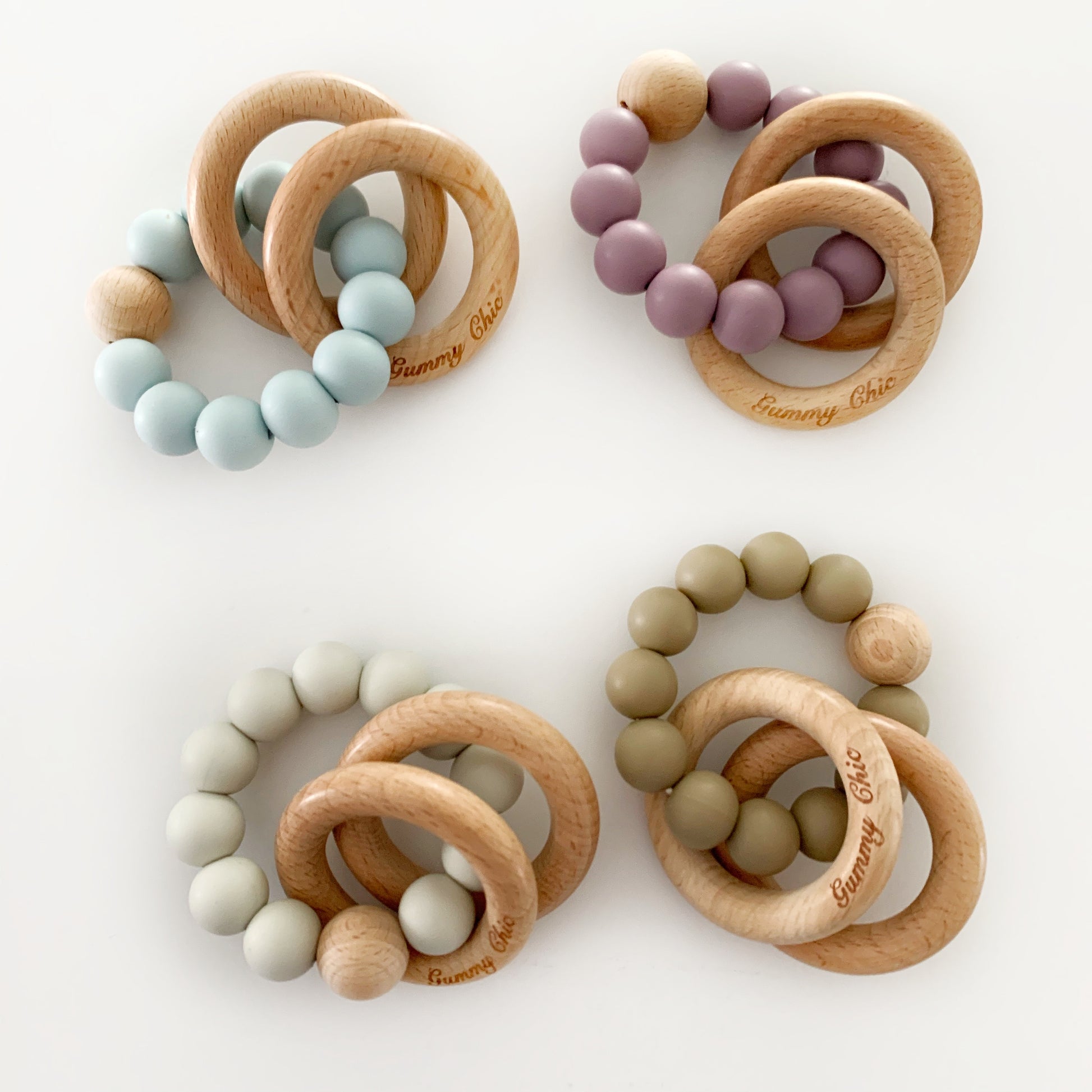 four teether ring rattles with silicone and wood, custom silicone bead colors and gummy chic written on the wooden rings