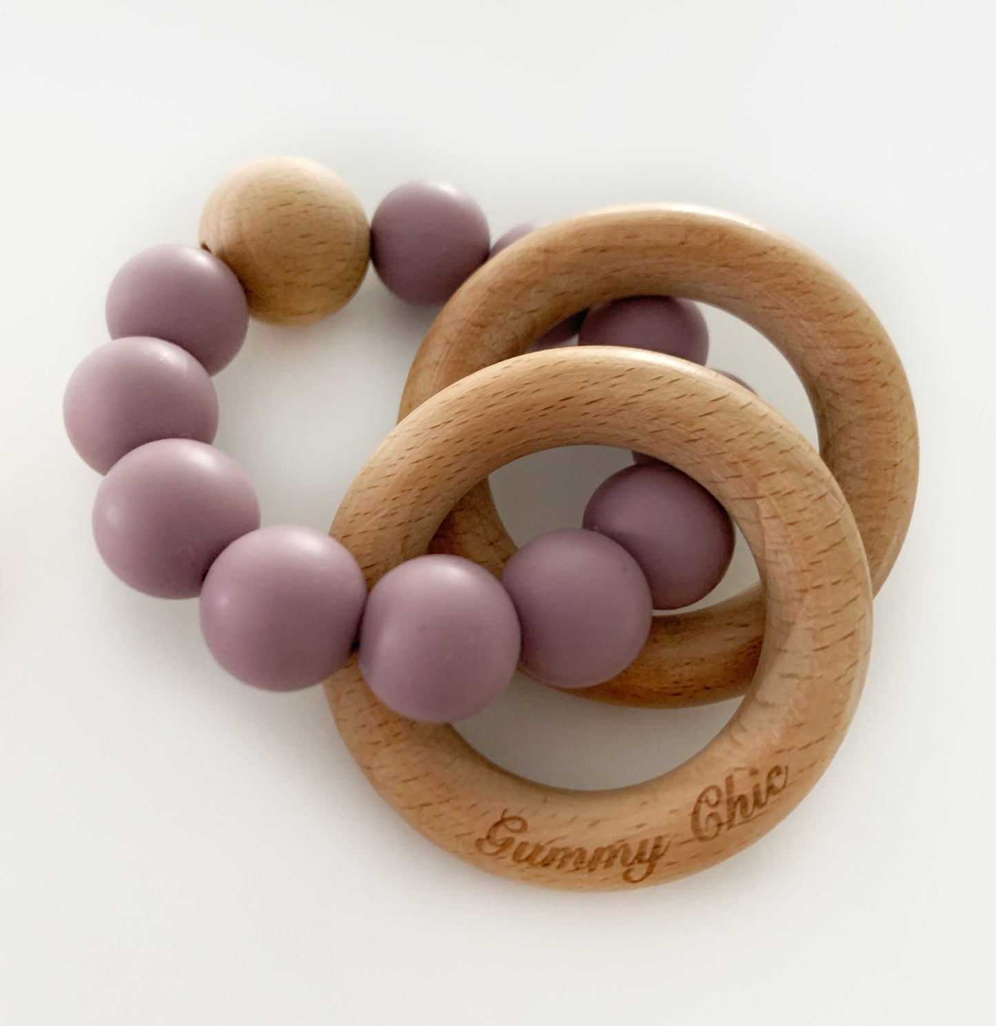 mauve silicone beads in a rattle silicone teether with gummy chic engraving on the wooden ring