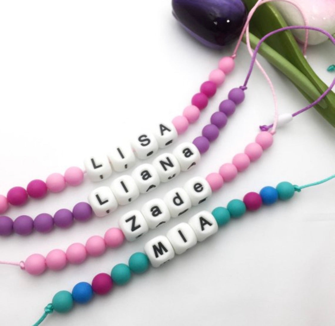 Personalized fidget chew necklace for kids with colorful beads and custom names Lisa, Liana, Zade, and Mia.