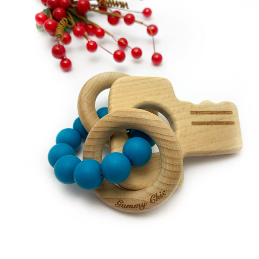 blue silicone beads around two wooden teethers in shape of a key for new baby