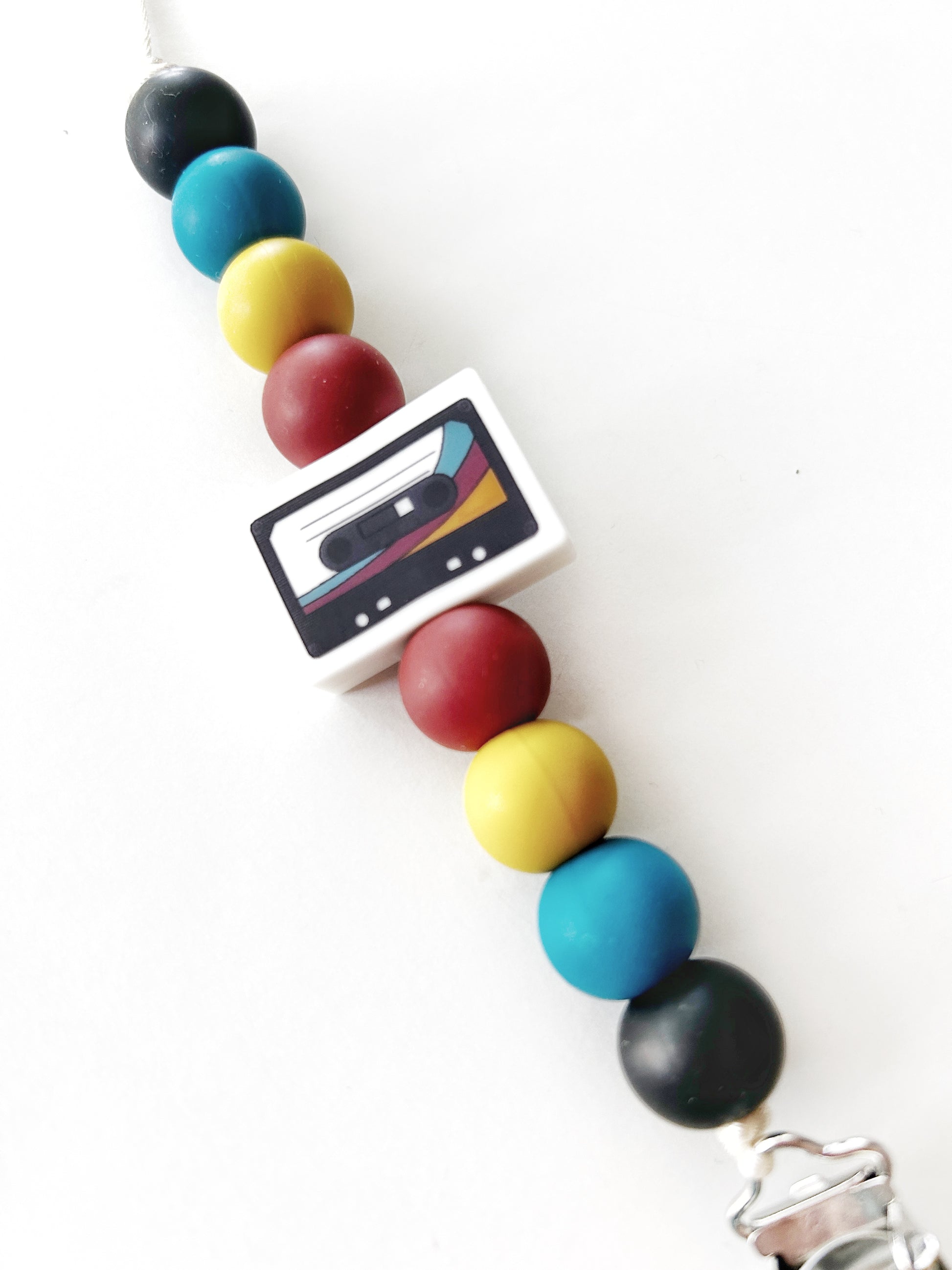 retro cassette bead in the center of a pacifier clip with colorful retro beads