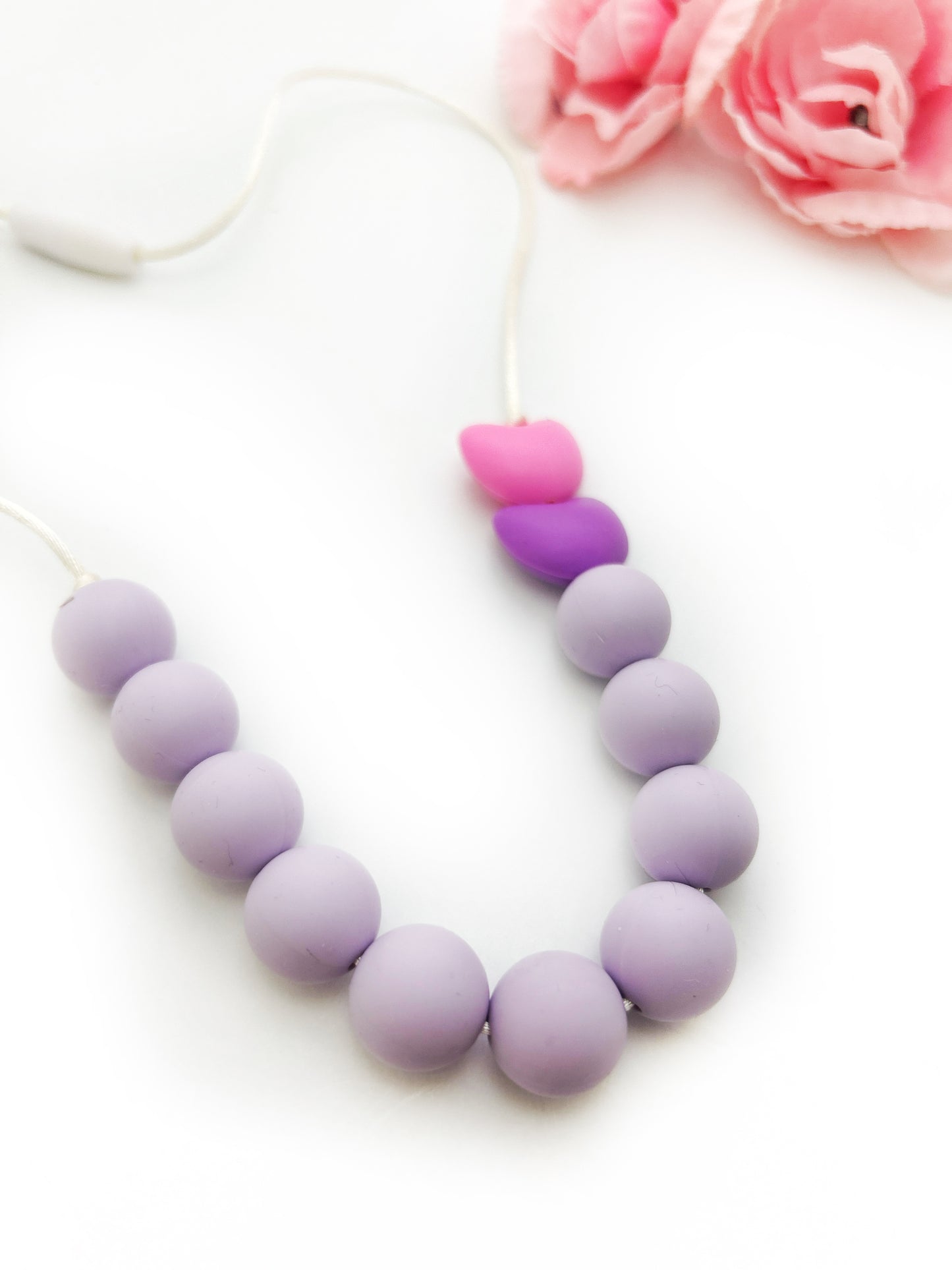 Necklace with purple and pink beads on a white background
