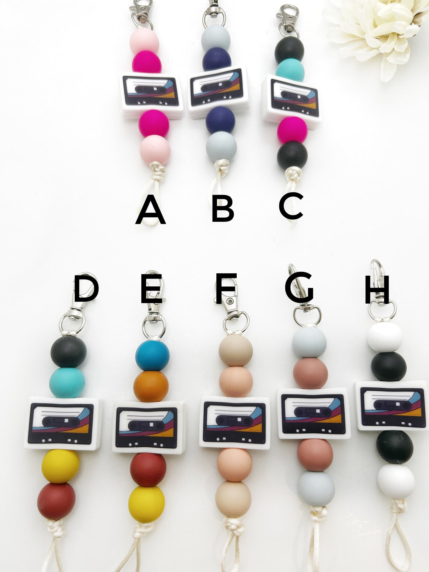 Set of colorful beaded lanyards with cassette tape design, labeled A to H.