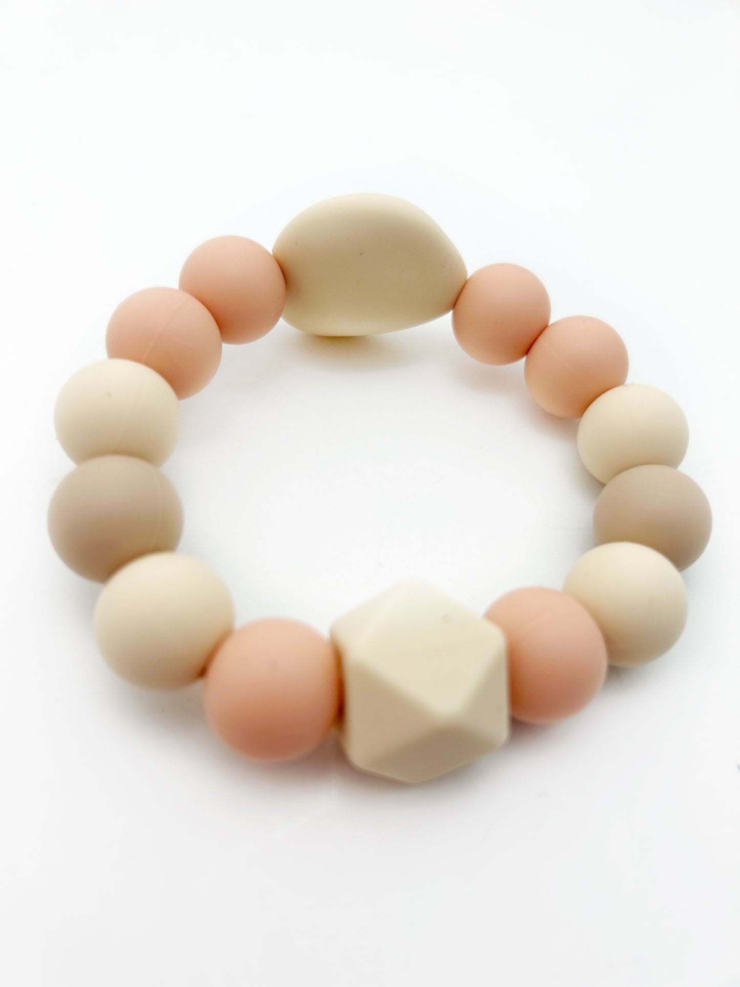 silicone teething ring in peach and beige colors with two accent beads and all silicone round beads