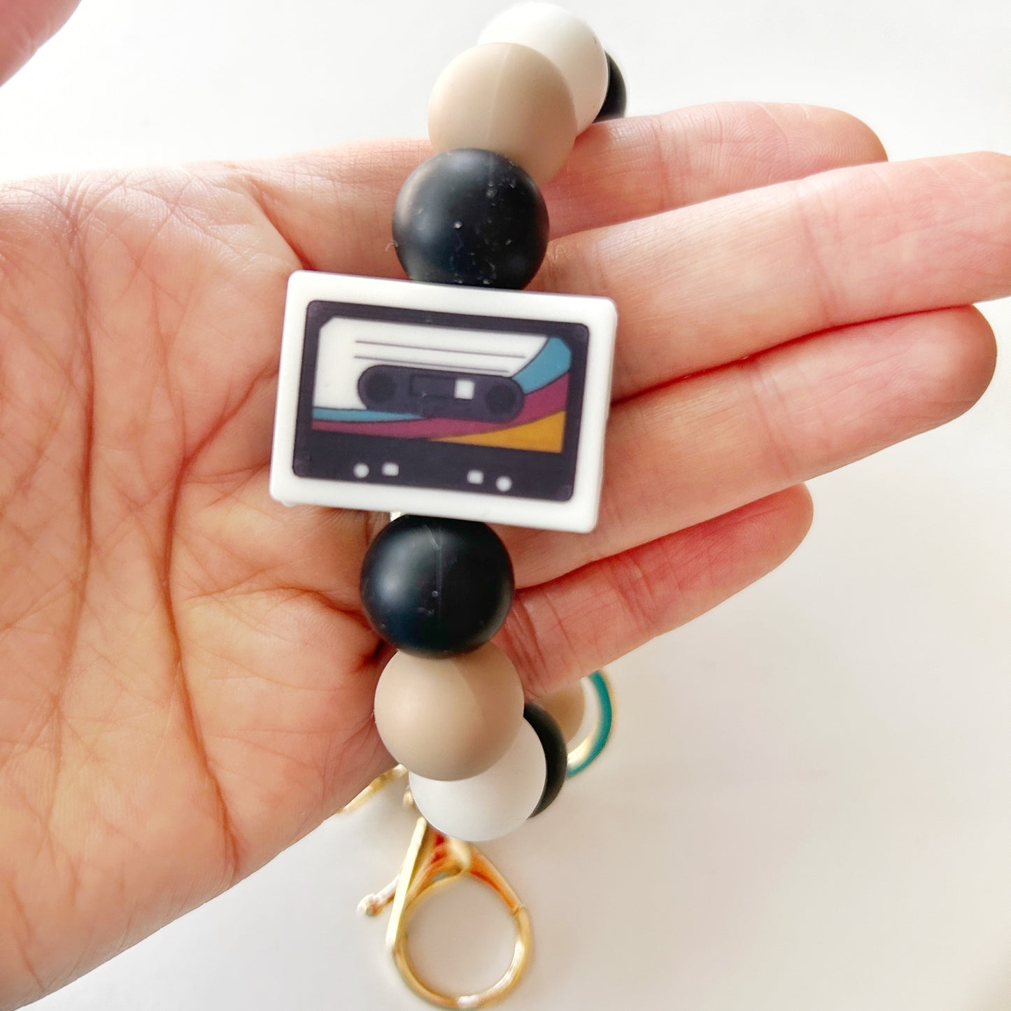 mix tape bead in blue, red and yellow on a silicone ring bracelet, a hand holding it.