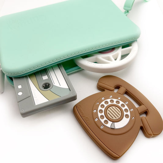 A multi purpose silicone bag in green color displayed alongside its uses as a wallet, baby wipe bag, and phone case, with items like a wallet, baby wipe, and phone partially inserted into the bag.