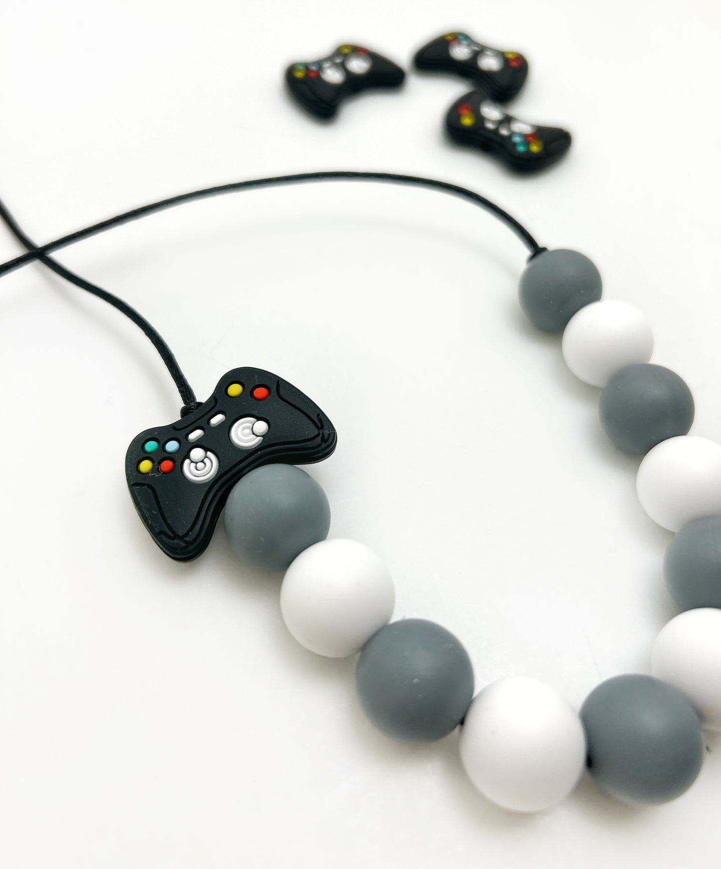 Necklace with a game controller charm and beads on a white background