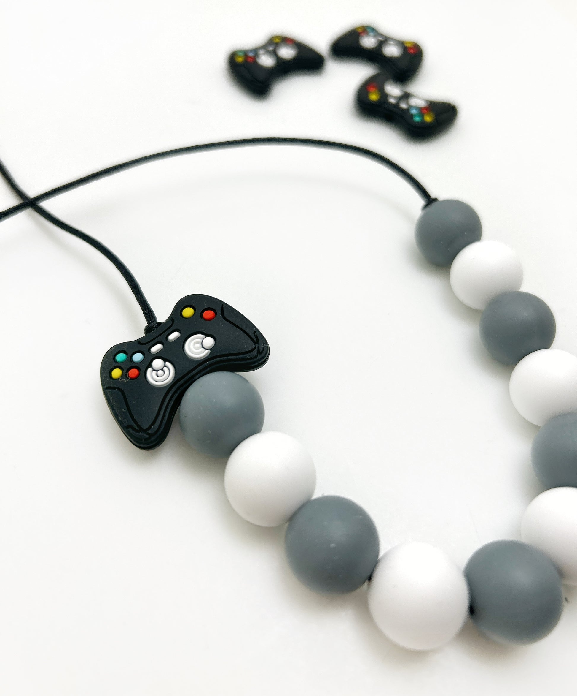 Necklace with a game controller charm and beads on a white background