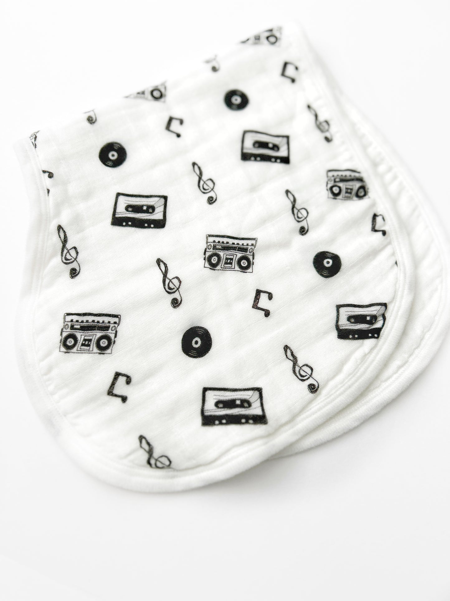 White baby booties with black music-themed pattern on a white background
