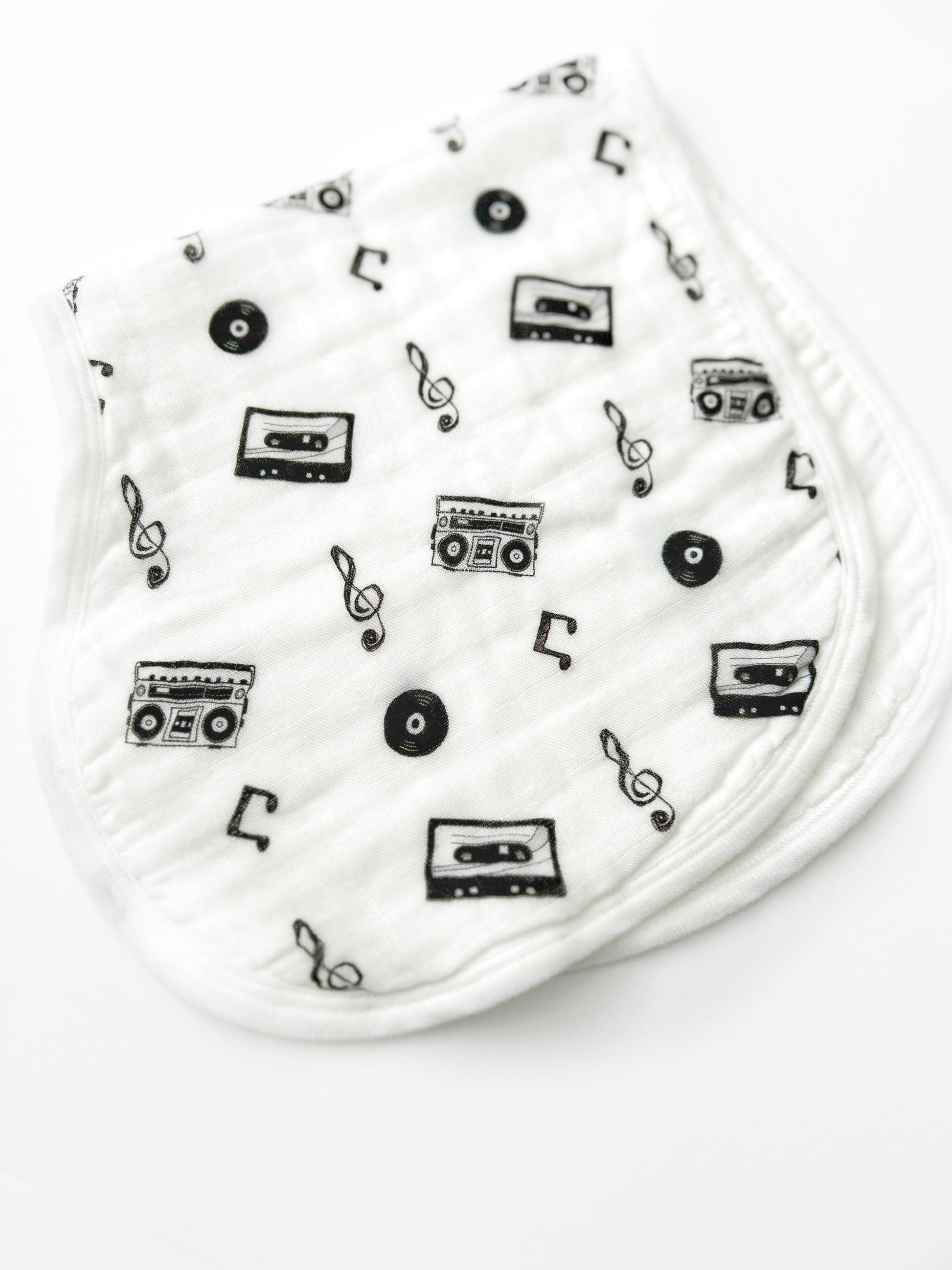 White baby booties with black music-themed pattern on a white background