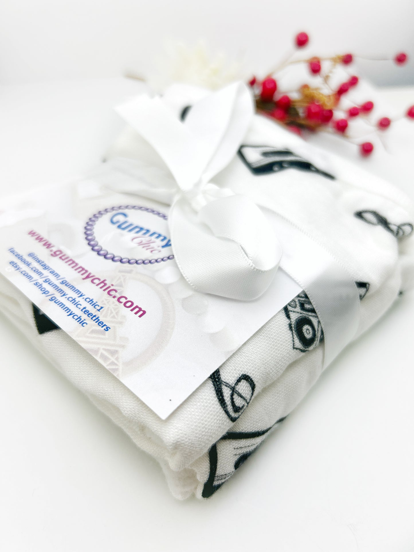 Folded white fabric with black patterns and a visible brand label on a white background.