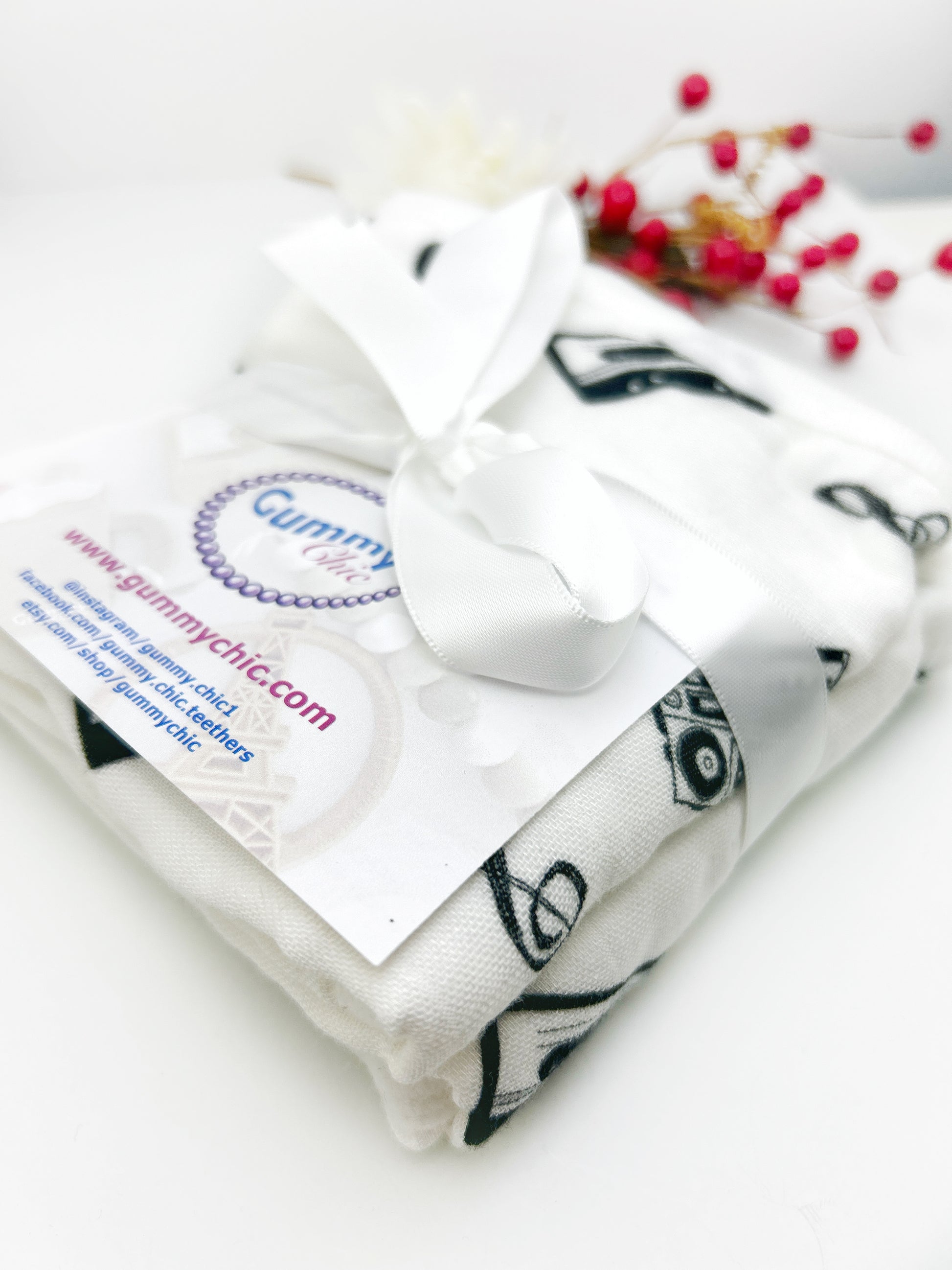 Folded white fabric with black patterns and a visible brand label on a white background.