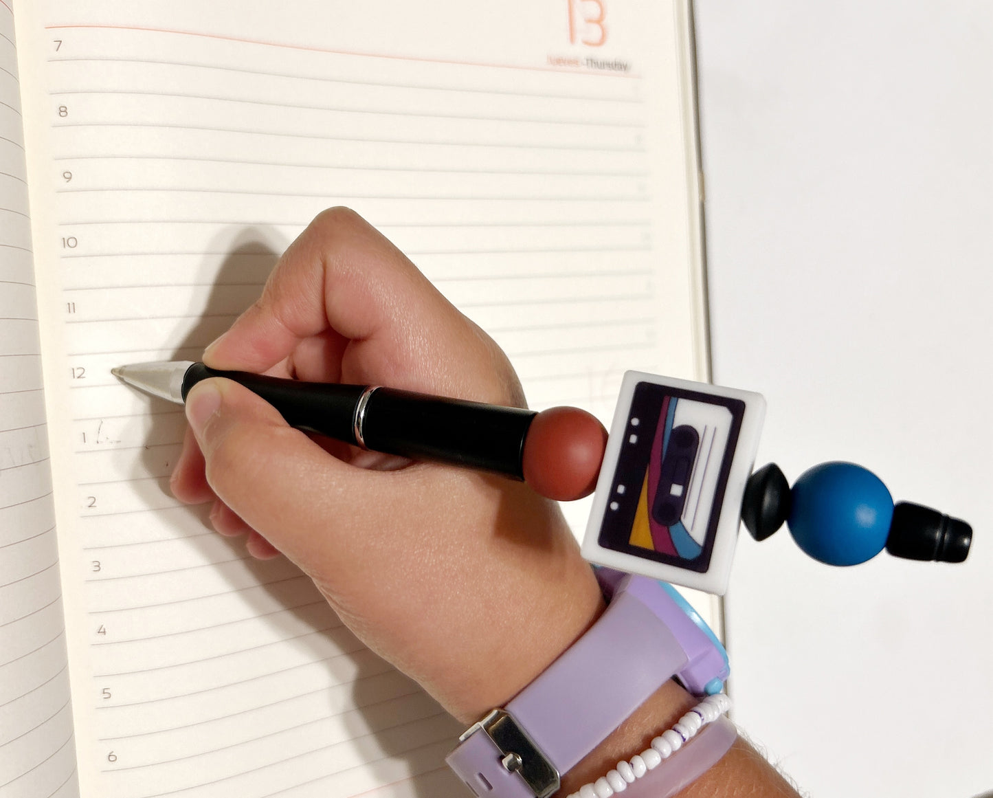 girl holding a mix tape beaded pen