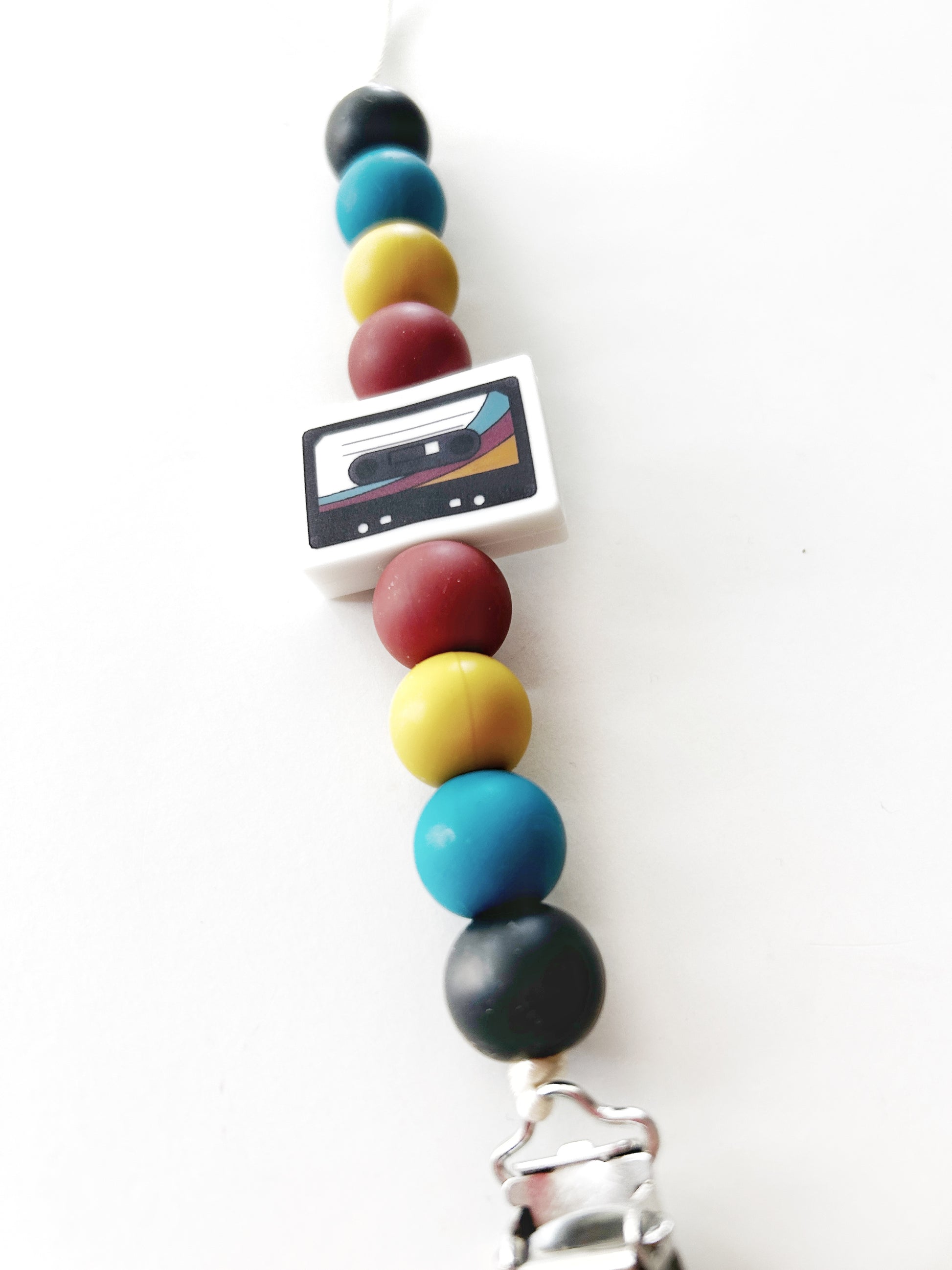 binky clip with retro colors with a cassette bead in the center.