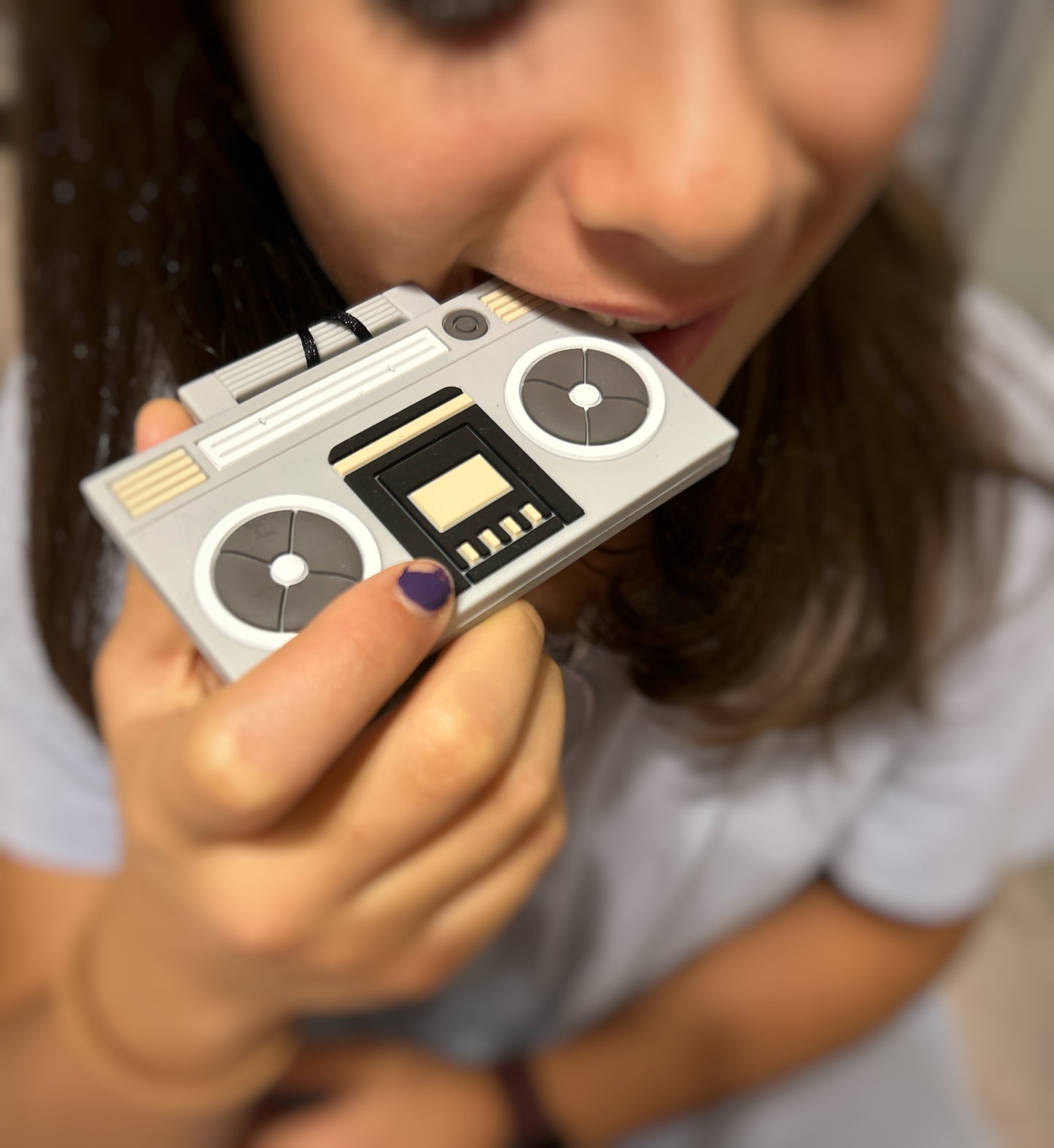 girl chewing on silicone boom box pendant