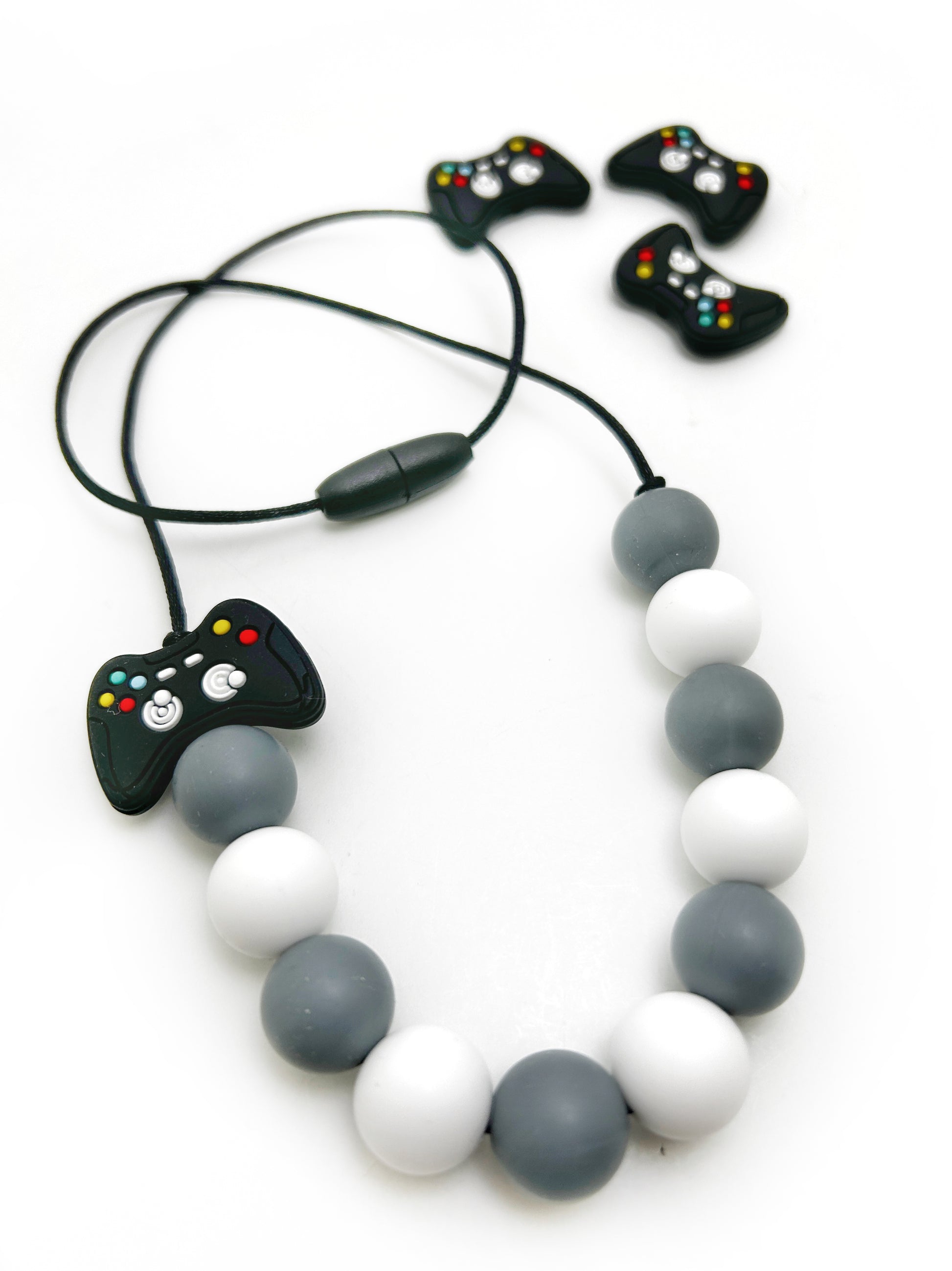 Necklace with video game controller charm and small controllers on a white background