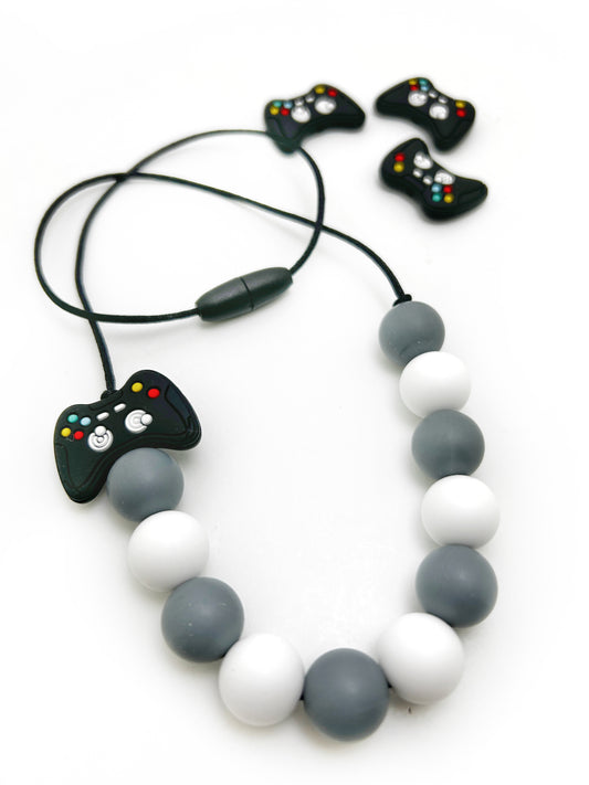Necklace with video game controller charm and small controllers on a white background