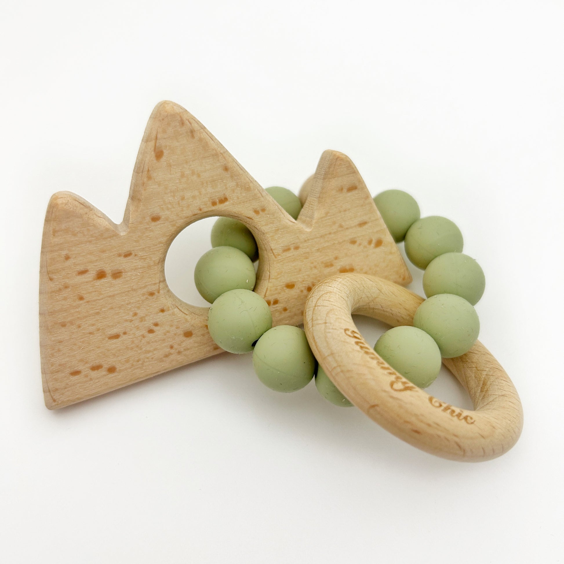 A wooden teether designed in the shape of a mountain with green silicone beads, crafted for little explorers.